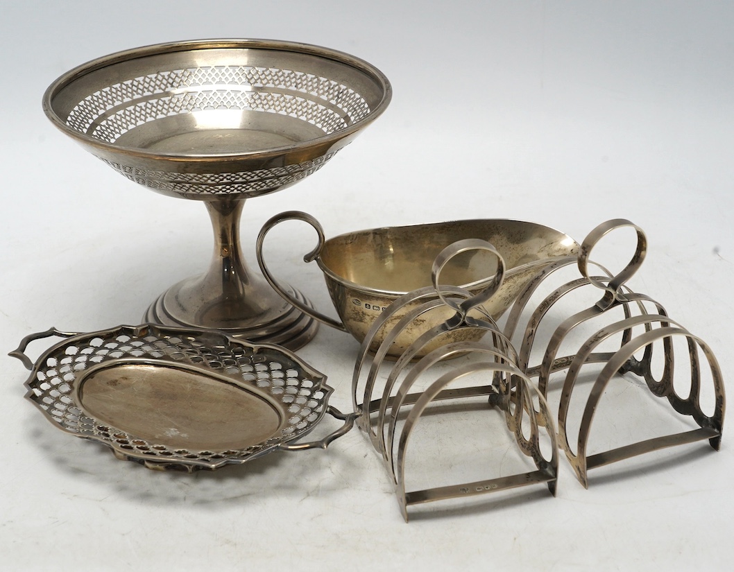 A pair of George VI silver five bar toast racks, Charles Boyton & Sons Ltd, London, 1937, 79mm, together with a small silver sauce boat, a silver two handled shallow dish and a pierced silver tazze, 15oz. Condition - fai